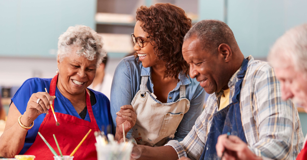 group of adult friends laughing at an art class 